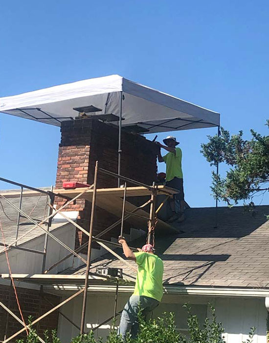 Group of workers fixing chimney