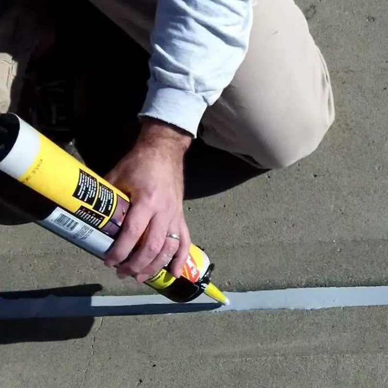 Man Caulking Driveway